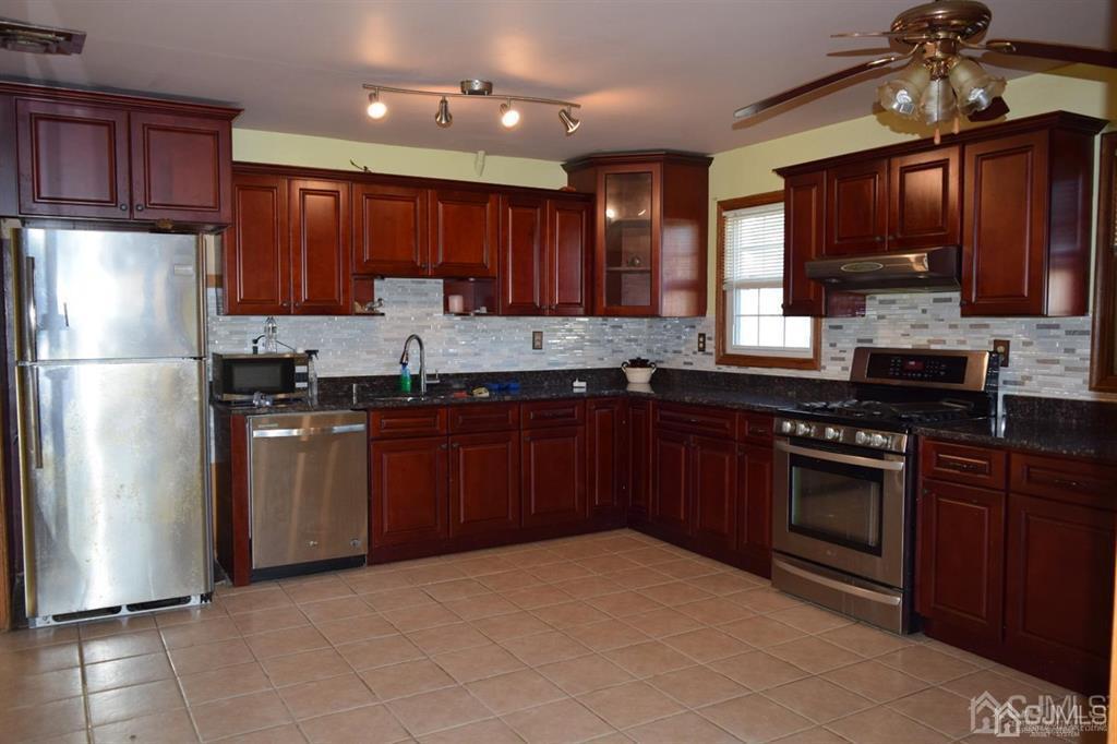 11 Post Boulevard Carteret, NJ 07008 - Photo 10 of 23 a kitchen with stainless steel appliances granite countertop a refrigerator stove a sink dishwasher and microwave