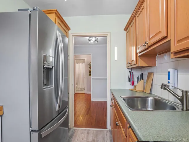 a kitchen with granite countertop a refrigerator and a stove top oven