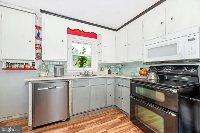 a kitchen with granite countertop a sink stainless steel appliances and cabinets