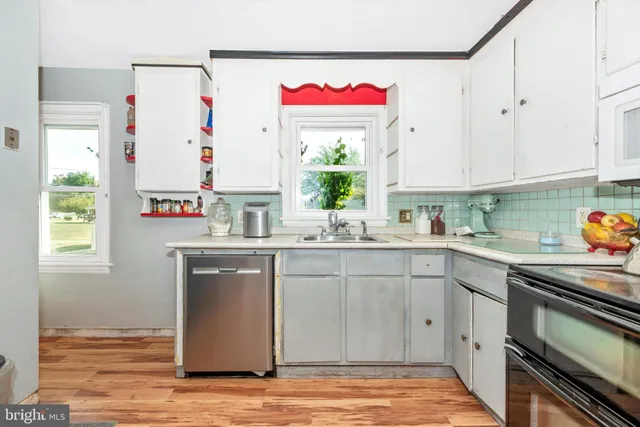 a kitchen with stainless steel appliances granite countertop a sink window and cabinets
