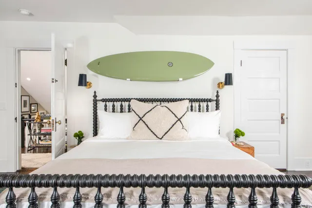 a bedroom with a large bed and a potted plant