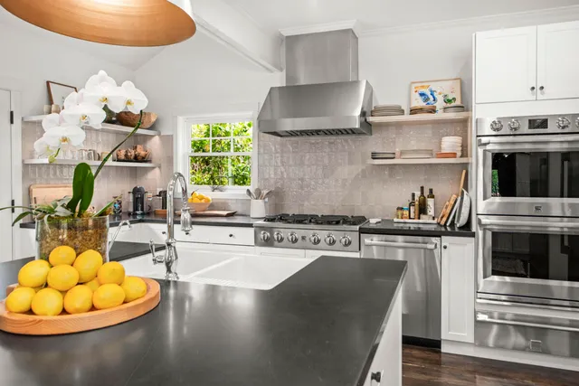 a kitchen with stainless steel appliances granite countertop a stove a sink and a microwave