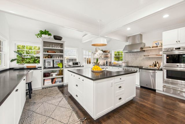 a kitchen with granite countertop a sink counter top space appliances and cabinets