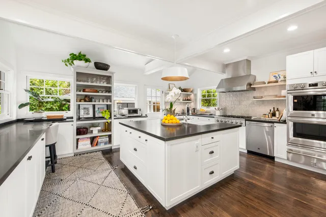 a kitchen with granite countertop a sink counter top space appliances and cabinets