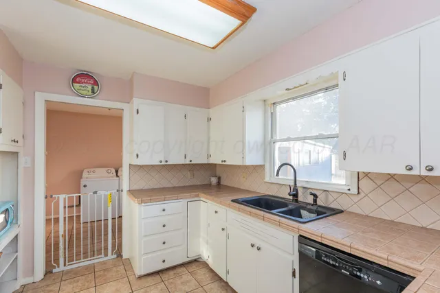 a kitchen with granite countertop a sink stainless steel appliances and cabinets