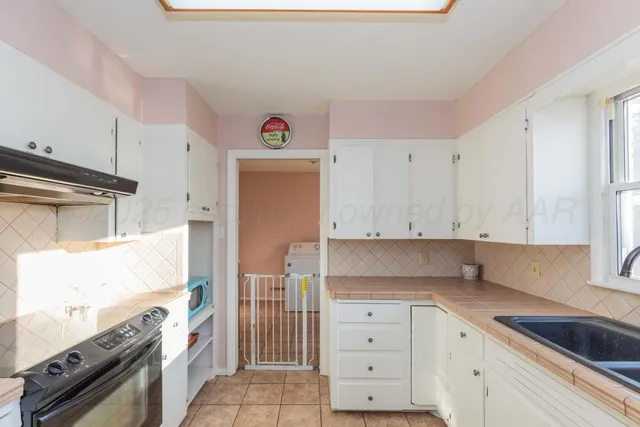 a kitchen with granite countertop white cabinets and white appliances
