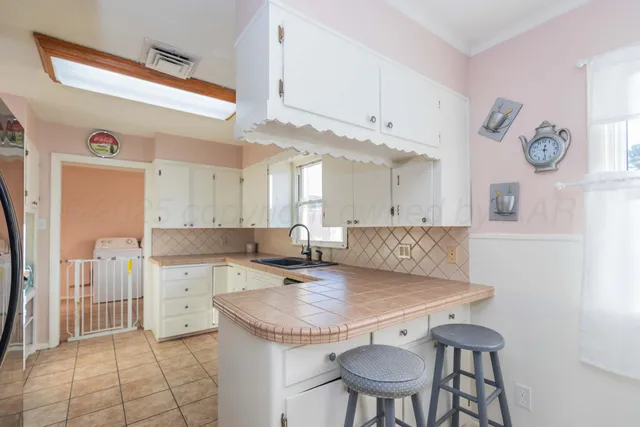 a kitchen with a table chairs and a refrigerator