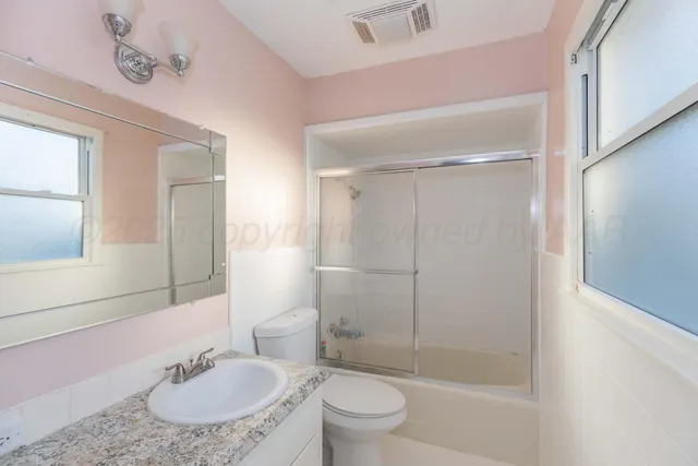 a bathroom with a sink toilet a mirror and shower