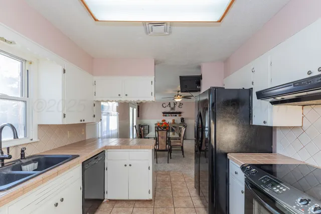 a kitchen with stainless steel appliances a refrigerator a sink a stove and cabinets