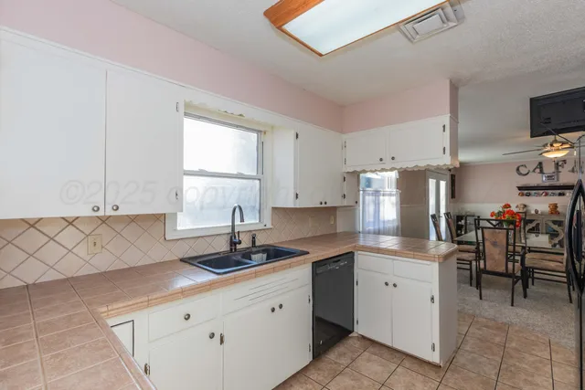 a kitchen with a sink window and cabinets