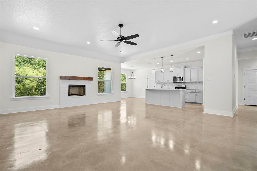 484 Clark Lake Road Weatherford, TX 76088 - Photo 6 of 21 a view of a kitchen with a stove cabinets a ceiling fan and wooden floor