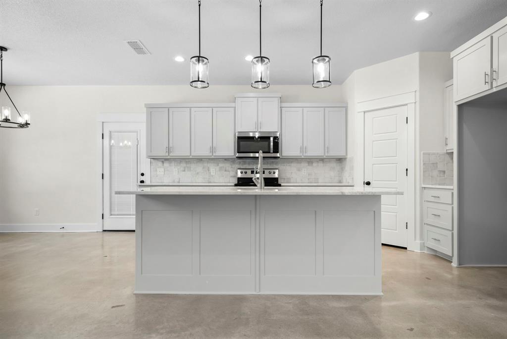 484 Clark Lake Road Weatherford, TX 76088 - Photo 10 of 21 a kitchen with kitchen island white cabinets and stainless steel appliances