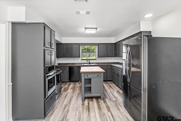 a kitchen with granite countertop a stove and a refrigerator
