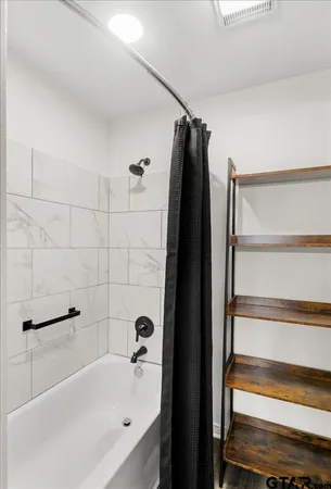 a bathroom with a sink vanity granite tub shower and a mirror