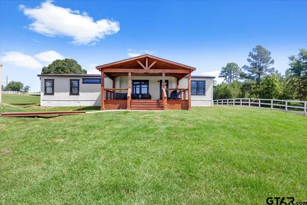 a living room with furniture and large windows