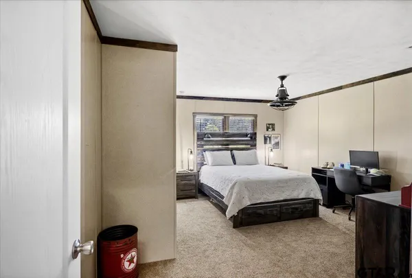 a bedroom with a bed flat screen tv and a window