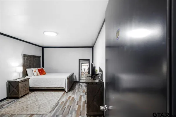 a bedroom with a bed a flat screen tv and dresser