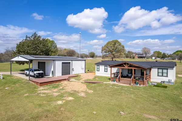 a view of a chairs and table in backyard of house