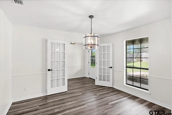 a view of empty room with fireplace and wooden floor