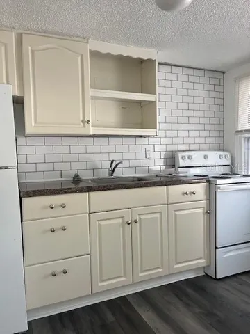 a kitchen with white cabinets and sink