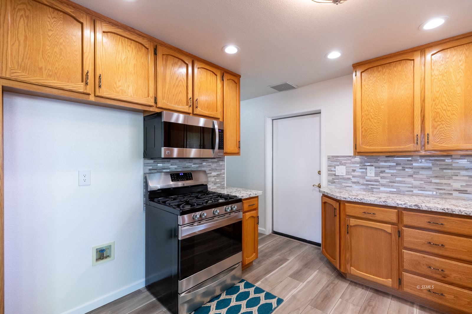 616 Yellow Astor Avenue Ridgecrest, CA 93555 - Photo 10 of 29 a kitchen with stainless steel appliances granite countertop a stove a sink and a microwave