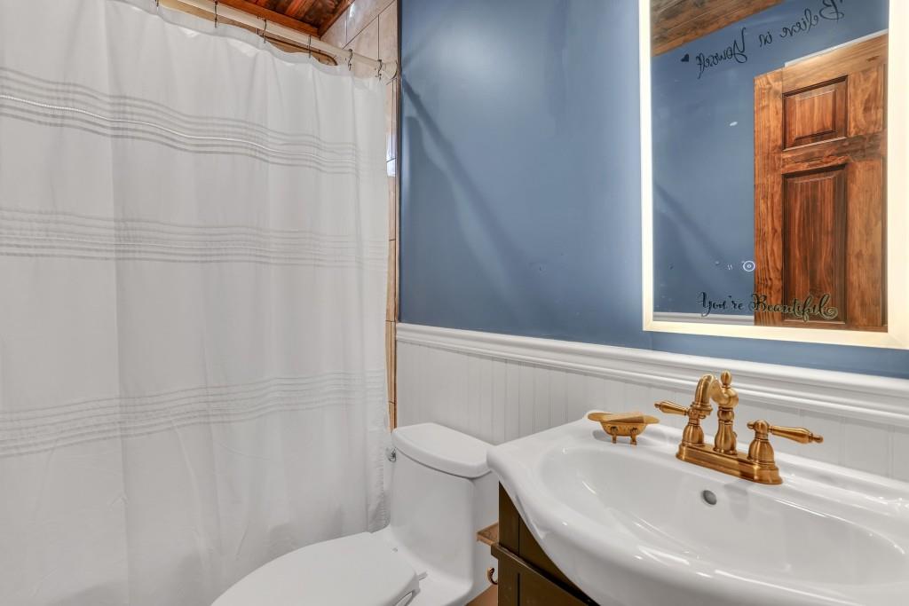 429 Red Oak Court Monroe, GA 30655 - Photo 22 of 40 a bathroom with a sink a toilet and shower curtain