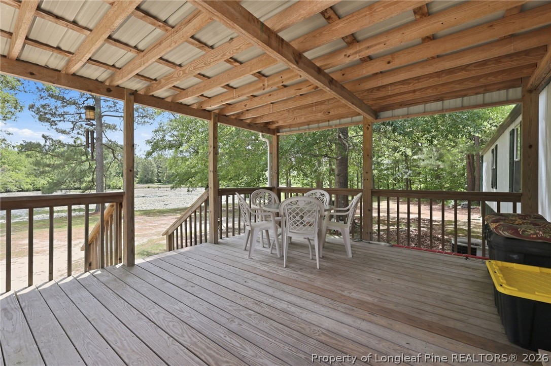 10400 Ruth Vinson Road Autryville, NC 28318 - Photo 39 of 49 a patio with wooden floor a yard tables and chairs