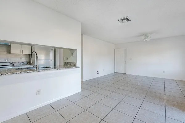 a kitchen with granite countertop a sink and cabinets