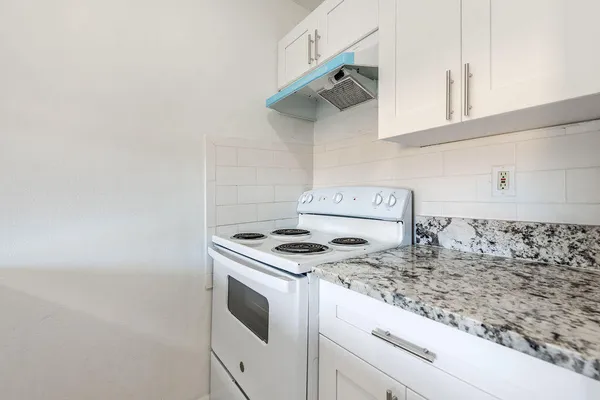 a kitchen with granite countertop cabinets and a stove