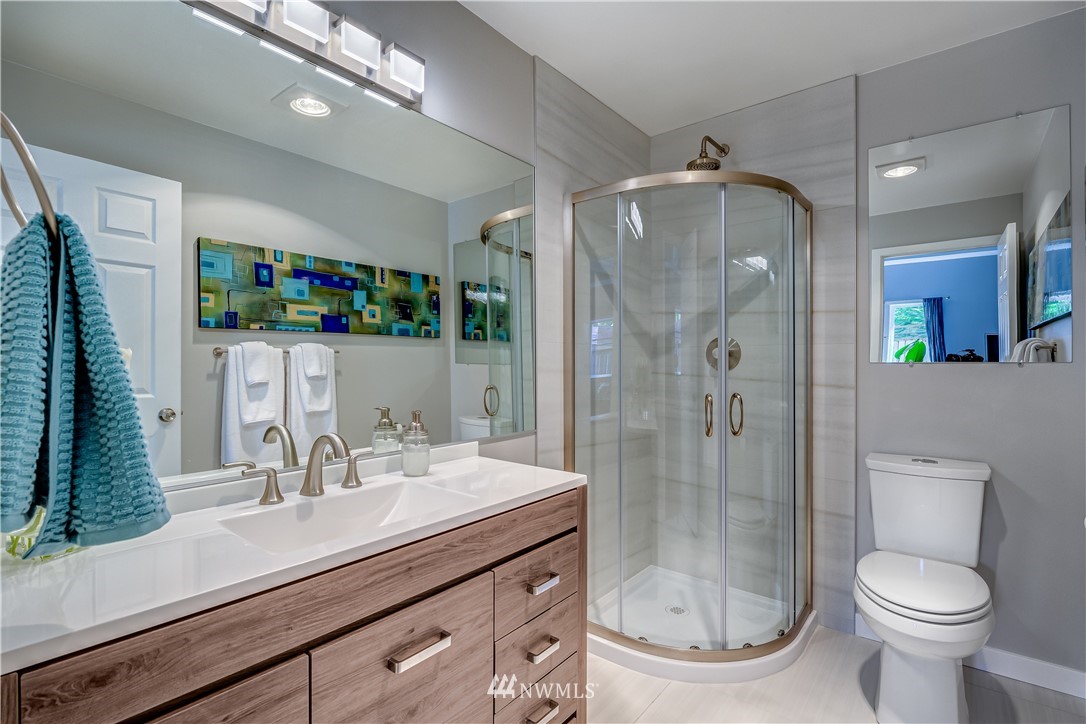 115 West Galer Street, Unit 101 Seattle, WA 98119 - Photo 15 of 23 a bathroom with a sink a mirror a toilet and shower