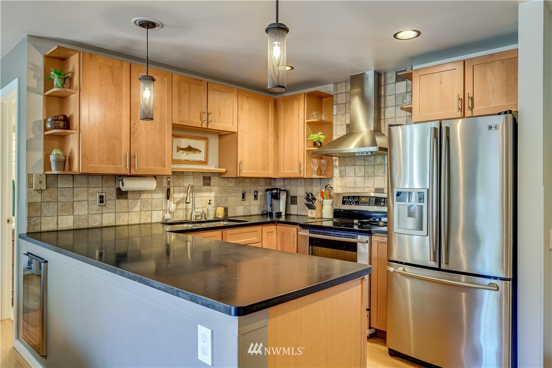 115 West Galer Street, Unit 101 Seattle, WA 98119 - Photo 5 of 23 a kitchen with stainless steel appliances granite countertop a refrigerator a sink a stove and a refrigerator