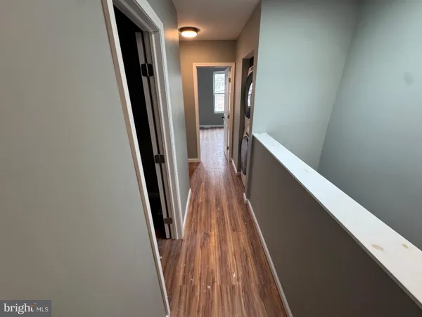 a view of a hallway with wooden floor and stairs