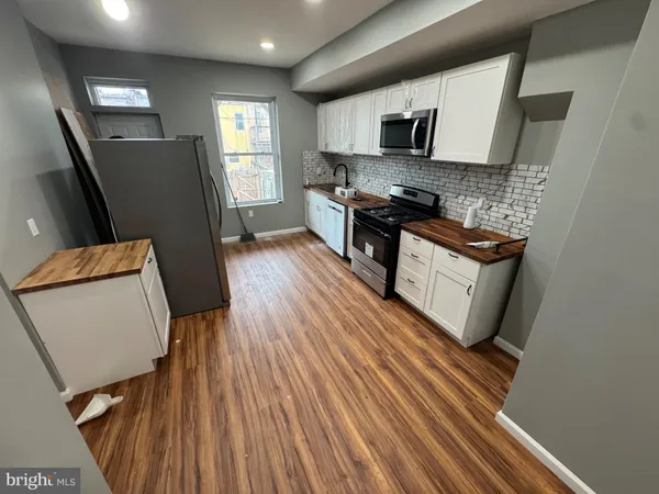 a kitchen with granite countertop wooden floors appliances and sink
