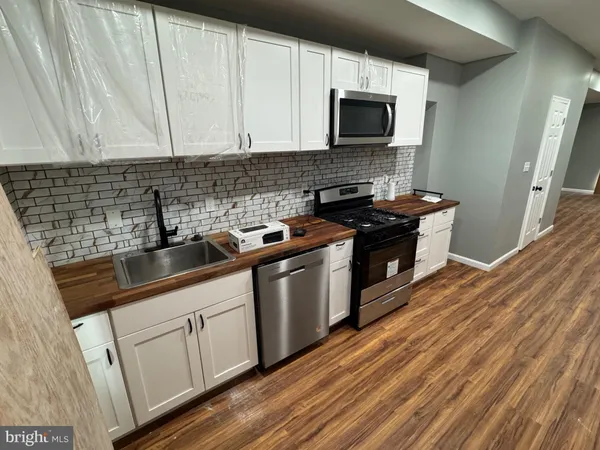 a kitchen with stainless steel appliances granite countertop a sink a stove and a microwave
