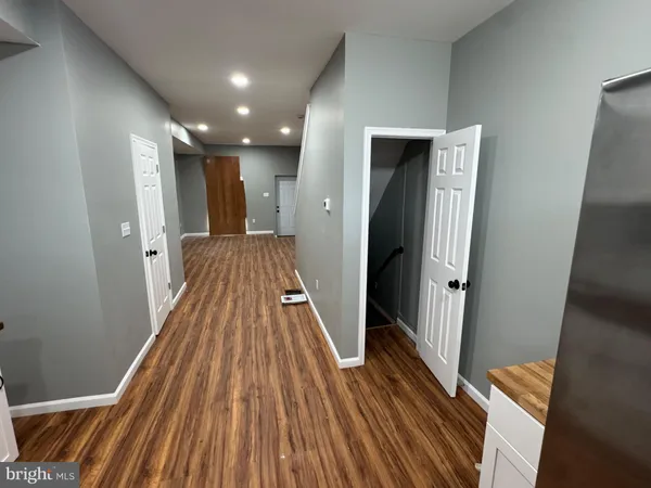 a view of a hallway with wooden floor and staircase