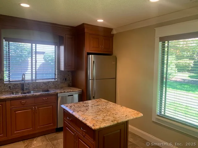 a kitchen with a sink a refrigerator and wooden cabinets
