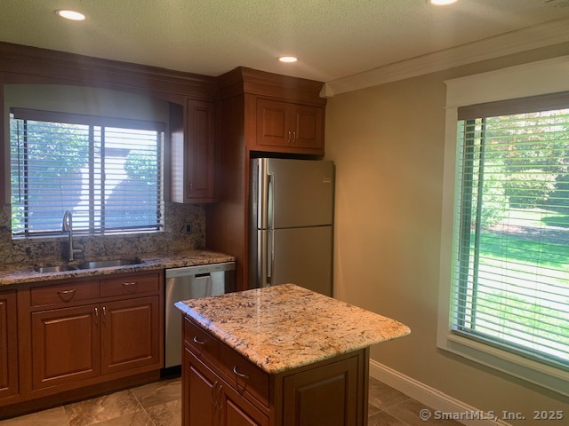 27 Canterbury Lane, Unit 27 Avon, CT 06001 - Photo 5 of 17 a kitchen with a sink a refrigerator and wooden cabinets