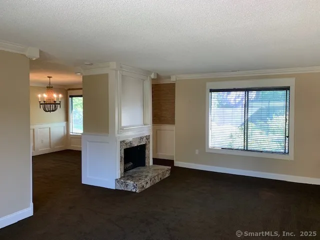 a view of an empty room with a fireplace and a window