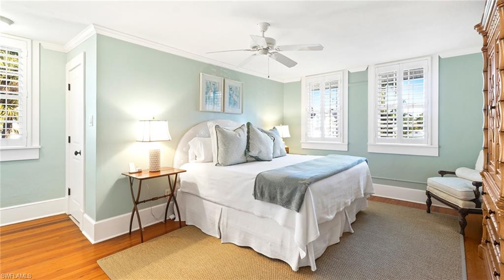 187 Broad Avenue South Naples, FL 34102 - Photo 11 of 33 a bedroom with a bed a chandelier and a window