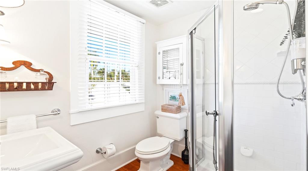 187 Broad Avenue South Naples, FL 34102 - Photo 16 of 33 a white toilet sitting next to a bathroom sink and tub