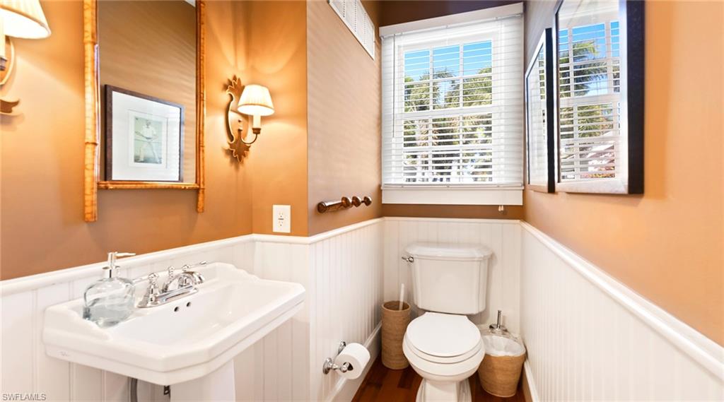 187 Broad Avenue South Naples, FL 34102 - Photo 18 of 33 a bathroom with a sink a toilet and a mirror