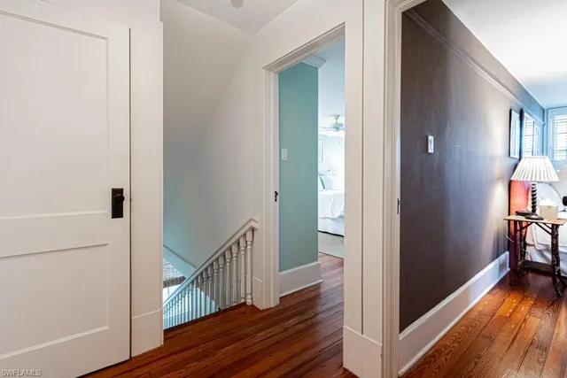 a view of a hallway with wooden floor and staircase