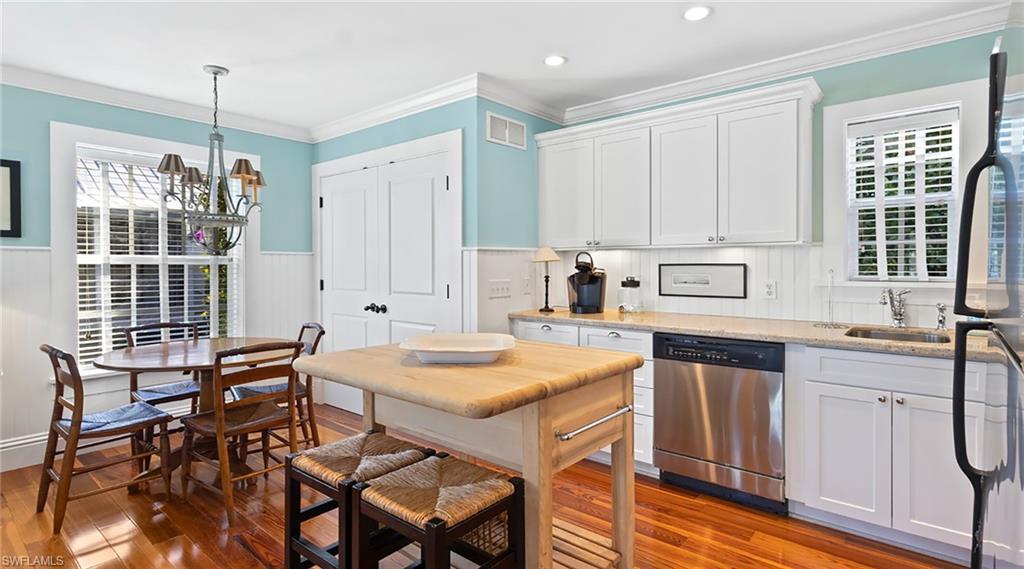 187 Broad Avenue South Naples, FL 34102 - Photo 25 of 33 Kitchen with white cabinets, stainless steel dishwasher, refrigerator, crown molding, and light stone counters