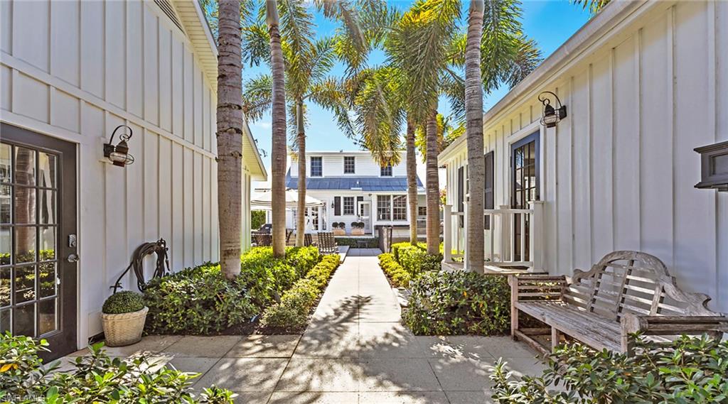 187 Broad Avenue South Naples, FL 34102 - Photo 29 of 33 a front view of a house with outdoor seating and plants