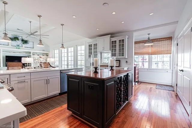 a kitchen with kitchen island granite countertop a sink appliances and cabinets