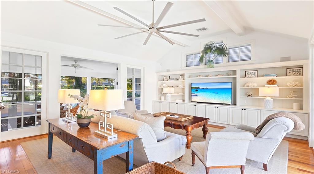 187 Broad Avenue South Naples, FL 34102 - Photo 9 of 33 a living room with furniture a flat screen tv and a table