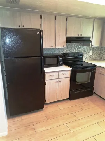 a kitchen with a stove top oven and cabinets