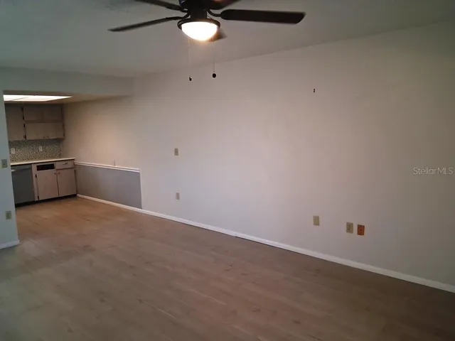 an empty room with a stove and chandelier fan