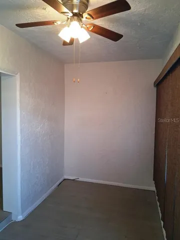 an empty room with a fan and a fan