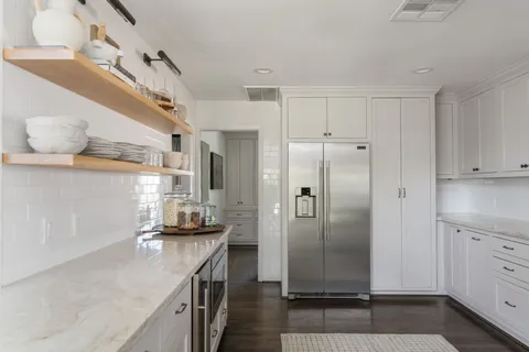 a kitchen with stainless steel appliances granite countertop a refrigerator and a stove